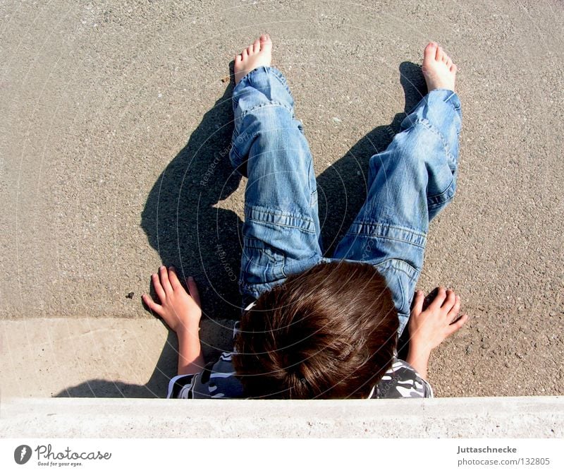 Warten auf Godot Kind Junge hocken Mauer Wand Beton anlehnen Vogelperspektive Pause Erholung Sonntag Barfuß lümmeln Parkplatz Langeweile Frieden boy boys