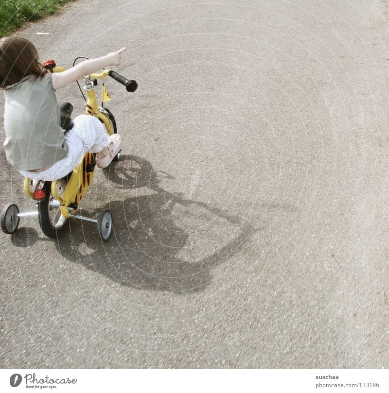 stuntkid I Asphalt Kind Kleinkind Mädchen klein Fahrradfahren Stunt Freestyle deuten frech Mut Extremsport Spielen Straße sitzen Stützräder zeigen unerschrocken