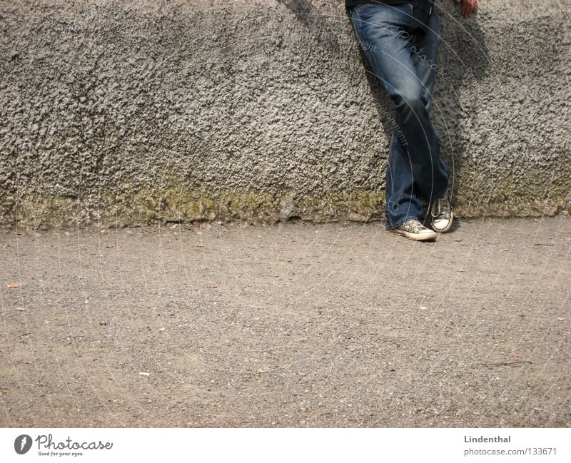 Warten Mauer stehen Mann Schuhe grau Beton weiß Hand Ausdauer gehen Wunsch Chucks anlehnen warten Jeanshose Ungeduld geduldig