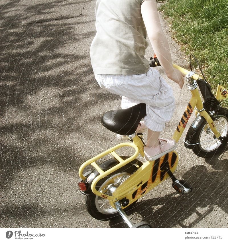 stuntkid 6 Asphalt Kind Kleinkind Mädchen klein Fahrradfahren stehen Stunt Freestyle frech Mut Freude Funsport Straße fahrad kunststück stützräder unerschrocken