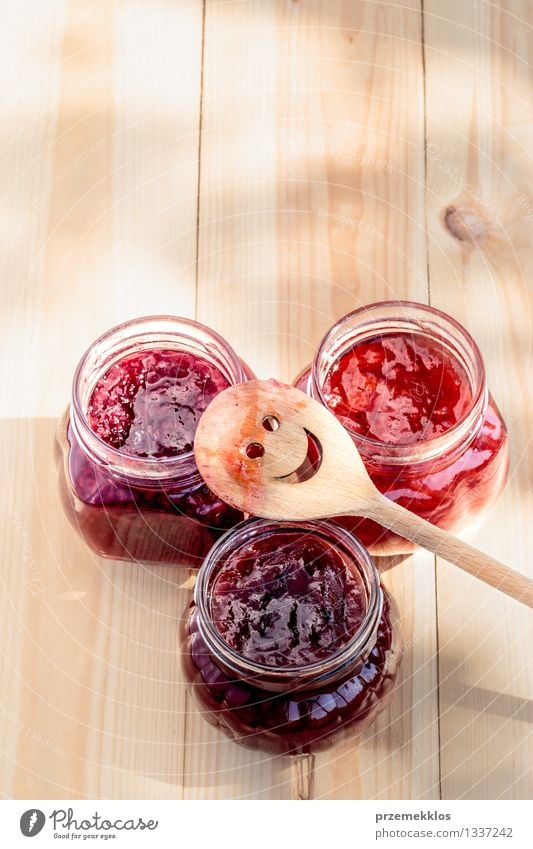 Hausgemachte Marmelade auf Holztisch Frucht Ernährung Frühstück Bioprodukte Löffel Sommer Tisch Natur frisch lecker natürlich rot Tradition Lebensmittel Glas