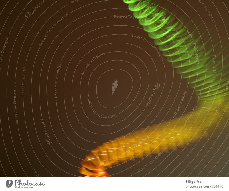 dynamisch Spielen Spielzeug Bewegung fliegen leuchten gelb grün orange Farbe Leichtigkeit Spirale Regenbogen Schwung gekrümmt Schweben gedreht Dynamik