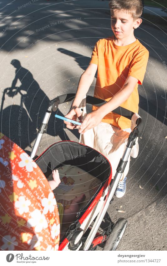 Kind mit dem Smartphone, der ein Foto des Babys macht Glück Sommer Sonne Telefon PDA Fotokamera Junge Natur Park Lächeln Zusammensein klein klug nehmen