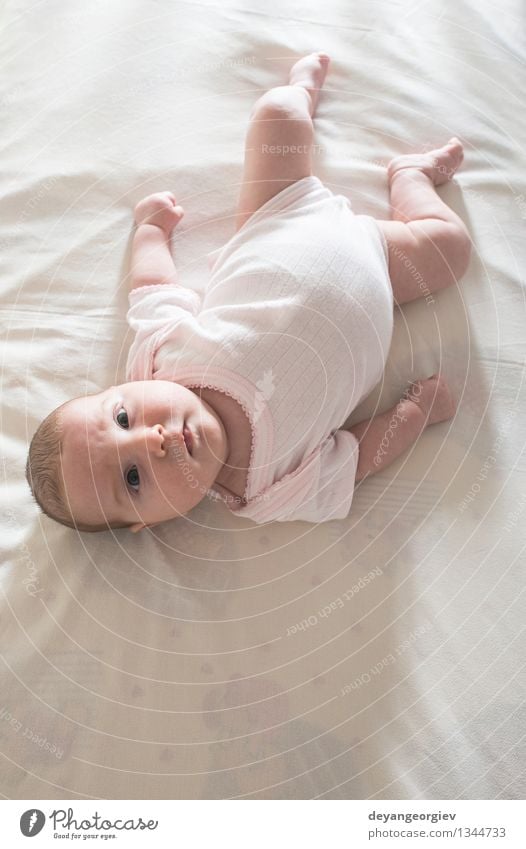 Baby in einem Babybett. Weiße Kleidung. Glück Gesicht Leben Kind Mädchen Lächeln schlafen klein weich weiß Bett neugeboren lügen reizvoll Kaukasier heimwärts