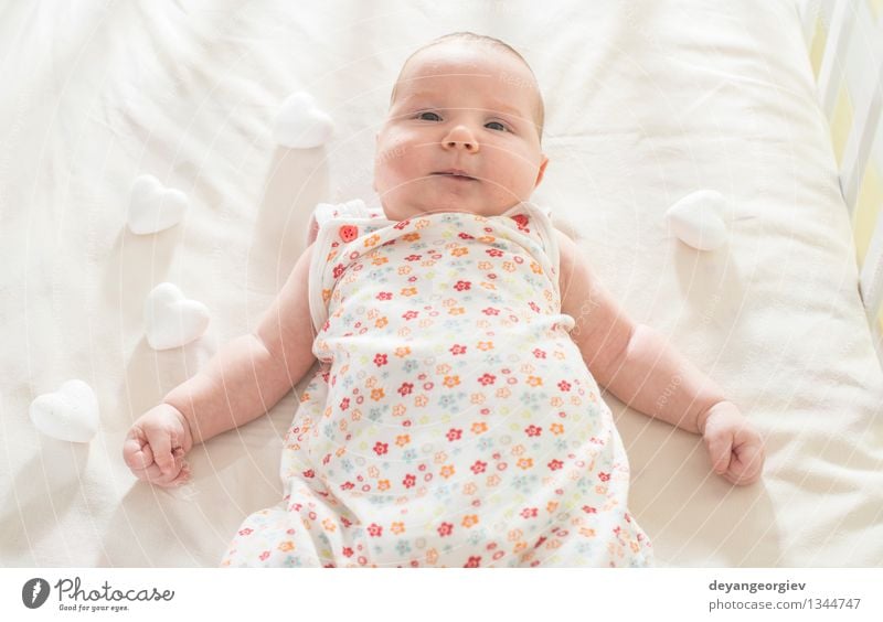 Baby in einem Babybett. Weiße Kleidung Glück Gesicht Leben Kind Mädchen Lächeln schlafen klein weich weiß Bett neugeboren lügen reizvoll Kaukasier heimwärts