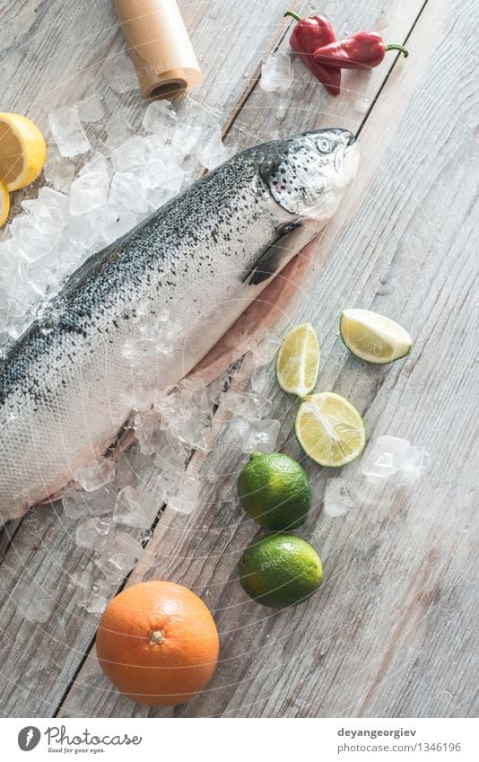 Rohe Lachsfische in Eis und Gemüse Meeresfrüchte Abendessen Tisch Koch Papier frisch lecker rot weiß Fisch Lebensmittel roh Zitrone Backpapier Messer hölzern