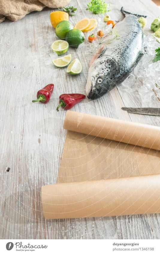 Rohe Lachsfische in Eis und Gemüse Meeresfrüchte Abendessen Tisch Koch Papier frisch lecker rot weiß Fisch Lebensmittel roh Zitrone Backpapier Messer hölzern