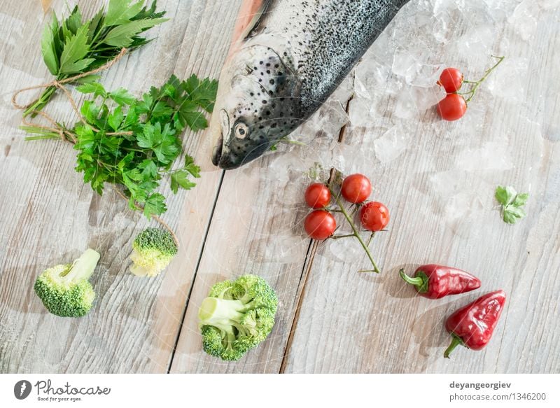 Rohe Lachsfische in Eis und Gemüse Meeresfrüchte Abendessen Tisch Koch Papier frisch lecker rot weiß Fisch Lebensmittel roh Zitrone Backpapier Messer hölzern