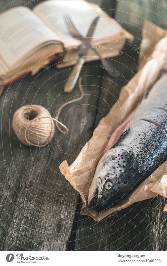 Rohe Lachsfische auf Weinleseholztisch Meeresfrüchte Mittagessen Gabel Tisch Seil Buch alt dunkel frisch Fisch altehrwürdig roh Lebensmittel Kochbuch