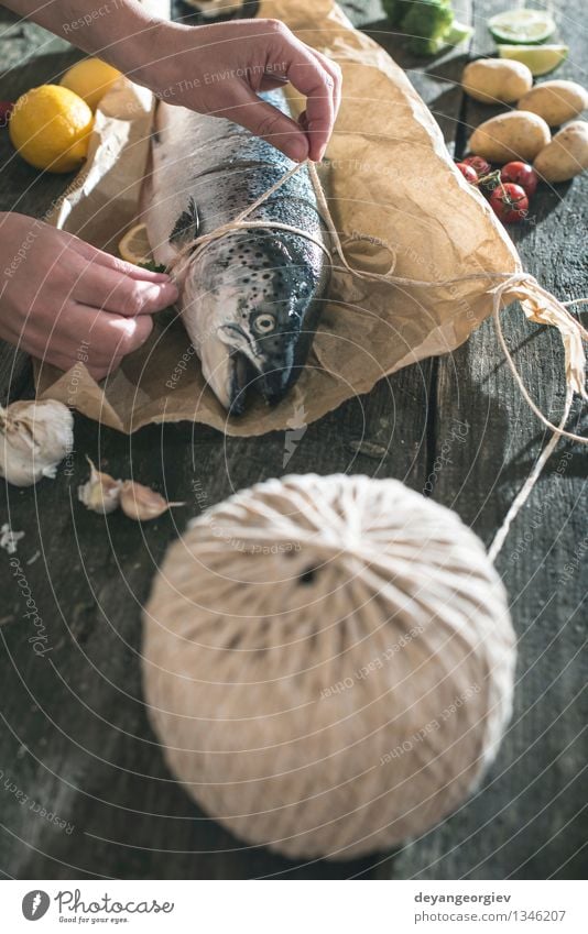 Ein Seil an Fische zum Grillen binden Meeresfrüchte Gemüse Abendessen Tisch Papier dunkel frisch lecker schwarz Lebensmittel kochen & garen roh altehrwürdig