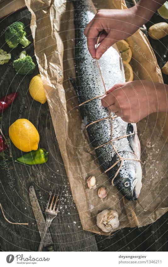 Ein Seil an Fische zum Grillen binden Meeresfrüchte Gemüse Abendessen Tisch Koch Hand Papier dunkel frisch lecker schwarz kochen & garen roh Zutaten Mahlzeit