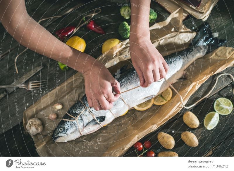 Ein Seil an Fische zum Grillen binden Meeresfrüchte Gemüse Abendessen Tisch Koch Hand Papier dunkel frisch lecker schwarz kochen & garen roh Zutaten Mahlzeit