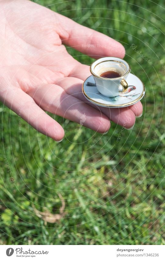 Hand halten sehr kleine Tasse Kaffee Getränk Espresso Garten Frau Erwachsene Arme Gras braun grün Halt Miniatur trinken Café Koffein aromatisch Nahaufnahme