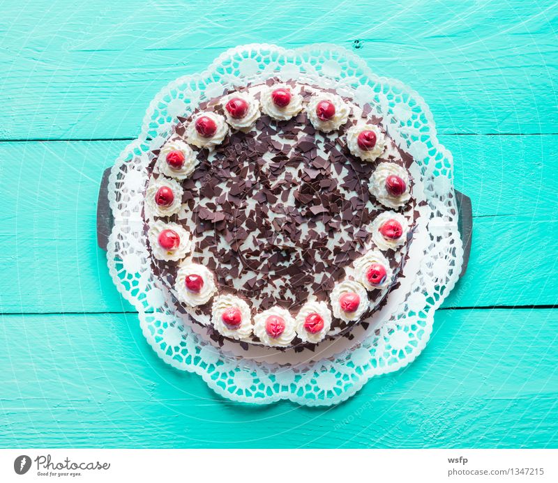 Schwarzwälder Kirschtorte auf türkisem Holz Kuchen Dessert Torte Sahnetorte Kirsche Schaumgebäck Tortenspitze Backwaren Biskuit süßes Holztisch Landhaus