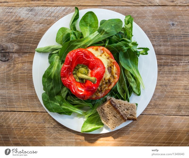 Gefüllte Paprika mit Hackfleisch Sauce und Käse überbacken Fleisch Brot Besteck Saucen Hauptgericht Brett Bretter Holztisch Landhaus rustikal Bräter Salat