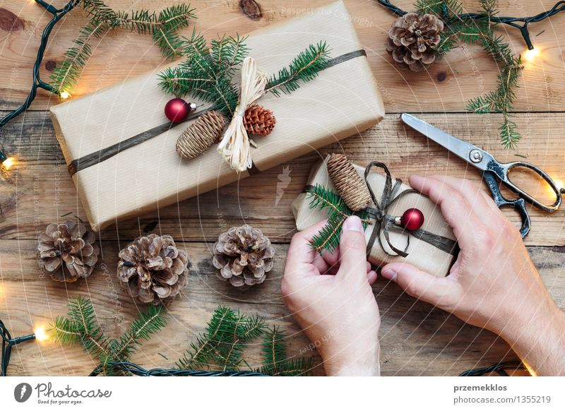 Dekorieren von verpackten Weihnachtsgeschenken Schere Hand Papier Paket Kasten Schnur Tradition Dezember Geschenk heimwärts horizontal Kiefer umhüllen Farbfoto