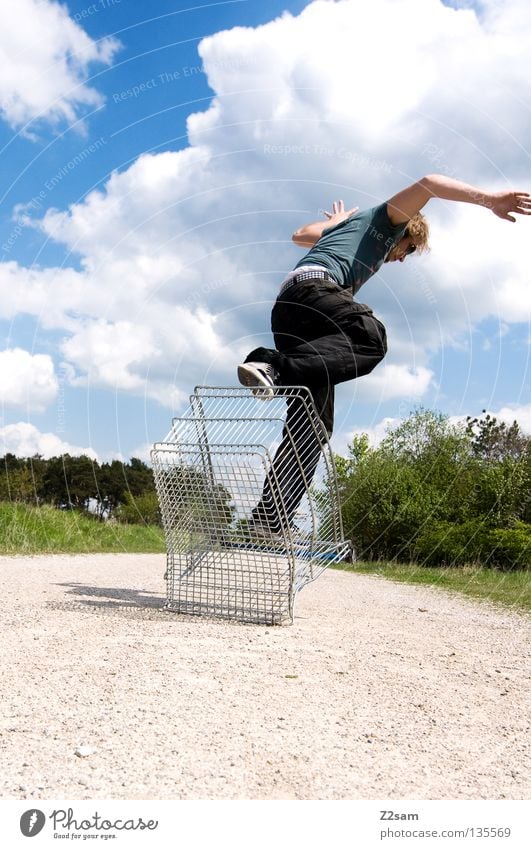 shopping surfer - absprung Wolken stehen Zufriedenheit Einkaufswagen Käfig Wiese grün Sommer saftig Physik sommerlich Mann maskulin Aktion gefährlich blond