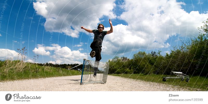 shopping surfer - flucht Wolken stehen Zufriedenheit Einkaufswagen Käfig Wiese grün Sommer saftig Physik sommerlich Mann maskulin Aktion gefährlich blond lässig