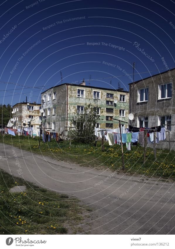 Lebensraum Haus Block Wohnung Wäsche Physik Sommer sozial Etage Wiese Fenster Flachdach Fassade Billig Putz Mauer Wohnsiedlung Ghetto Stadt Spielplatz trocknen