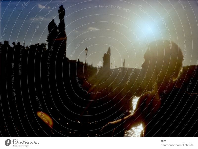 Mann vor Stadtpanorama Prag Karlsbrücke Sonnenuntergang Sonnenaufgang Skulptur Kuppeldach Statue Dach Turm Kran Stillleben Baustelle historisch Porträt