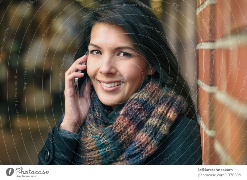 Lächelnde Frau in Autumn Fashion Talking am Telefon Lifestyle Glück schön Gesicht Winter sprechen PDA Erwachsene Herbst Stadt Straße Mantel Schal brünett