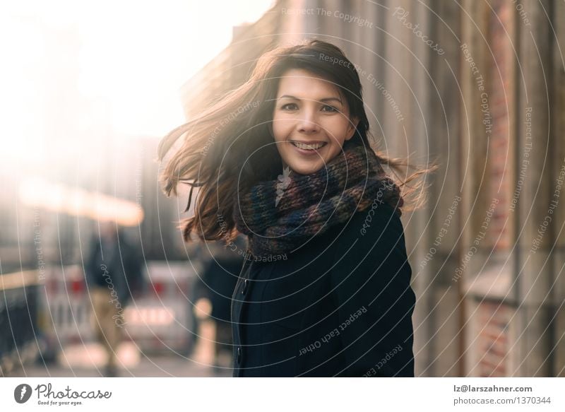 Glückliche Frau mit einem reizenden Lächeln auf einer Winterstraße Lifestyle Freude Gesicht Freiheit Sonne Erwachsene 1 Mensch 30-45 Jahre Natur Herbst Wind