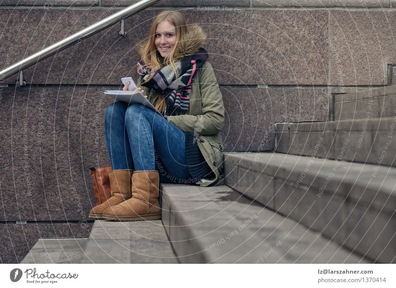 Attraktiver Jugendlicher, der auf Schritten in der Stadt sitzt Lifestyle Glück Gesicht lesen Winter Schule lernen Telefon PDA Mädchen Frau Erwachsene 1 Mensch