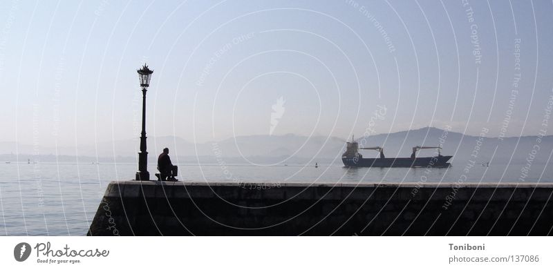 Tanker II Wasserfahrzeug lang Navigation Schifffahrt Handel Spanien Frachter Koloss Mann Laterne Anlegestelle Mole Fernweh Trauer schlechtes Wetter Meer Erdöl