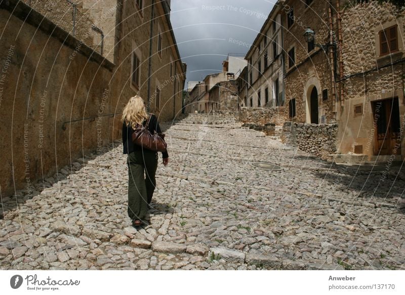 Frau auf dem Weg nach oben - Gasse in Pollenca, Mallorca gehen aufsteigen anstrengen aufwärts blond Hauseingang schweißtreibend Sightseeing Spanien Spaziergang