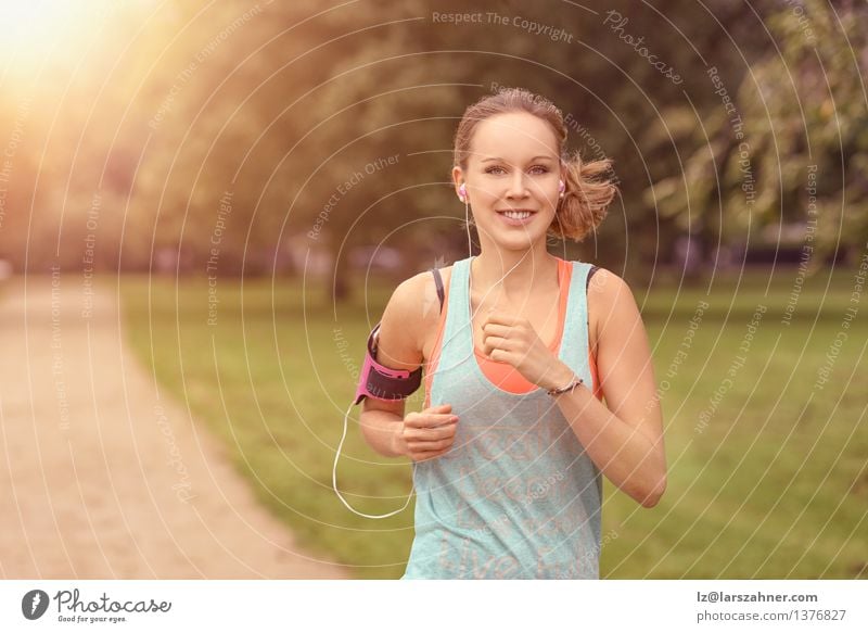 Hübsche Frau, die am Park mit Kopfhörern rüttelt Lifestyle Glück Sommer Musik Sport Joggen Erwachsene Landschaft Herbst Blatt Straße Bewegung Fitness hören