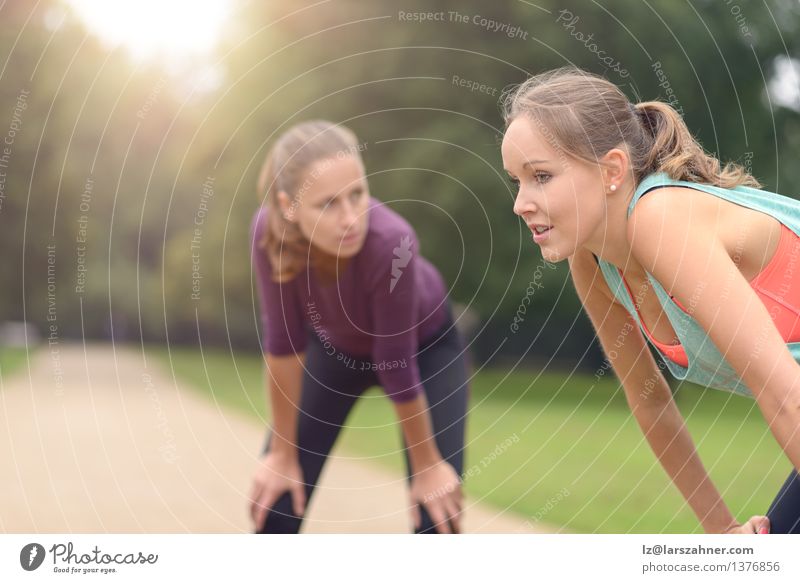 Frauen, die nach ihrer Übung im Freien stillstehen Lifestyle Gesicht Sport Joggen Mädchen Erwachsene Freundschaft Park Wege & Pfade blond Fitness Lächeln 20s