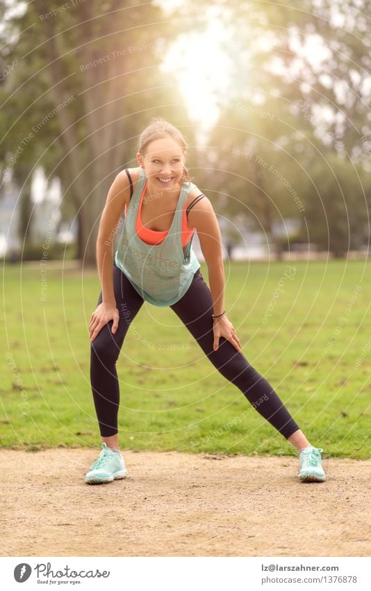 Athletische junge Frau, die Übungen ausdehnend tut Lifestyle Glück Körper Wellness Sommer Erwachsene Natur Park Fitness Lächeln sportlich Fröhlichkeit muskulös