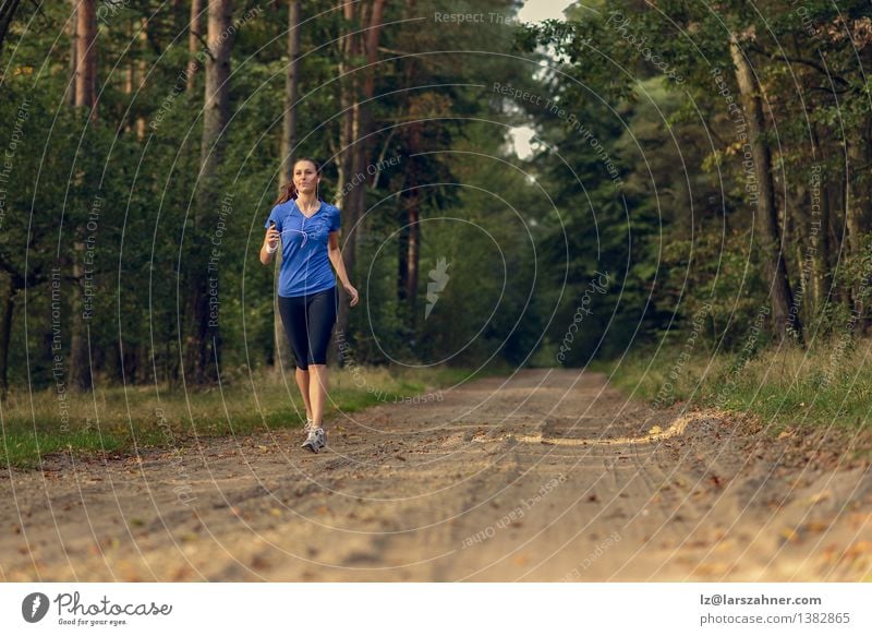 Athletische Frau, die heraus in einem Wald rüttelt Lifestyle Körper Musik Sport Joggen Technik & Technologie Mädchen Erwachsene 1 Mensch 13-18 Jahre Jugendliche