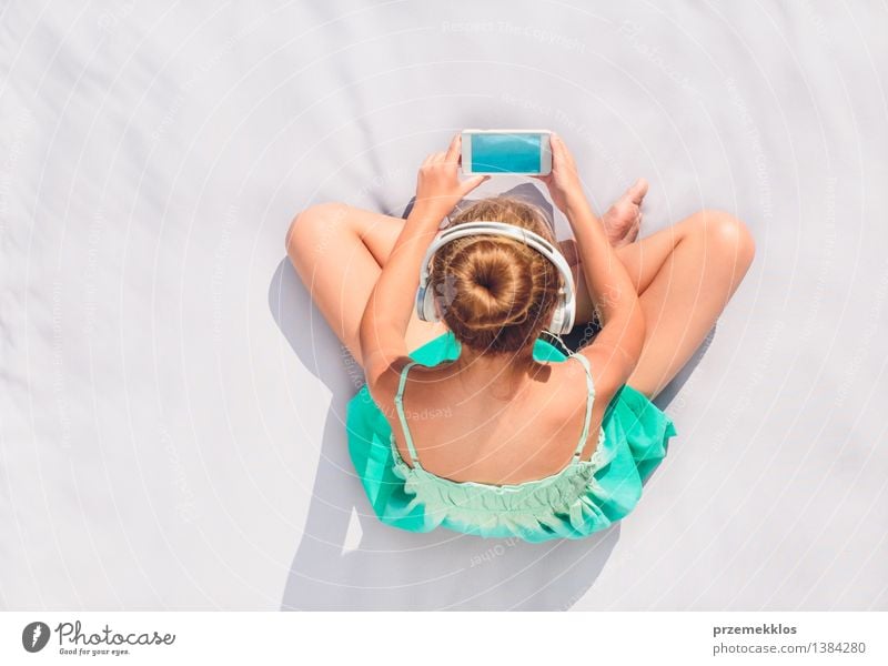 Junges Mädchen sitzt auf einer Decke im Freien und hört Musik vom Mobiltelefon Lifestyle Erholung Freizeit & Hobby Sommer Kind Telefon Mensch Jugendliche 1