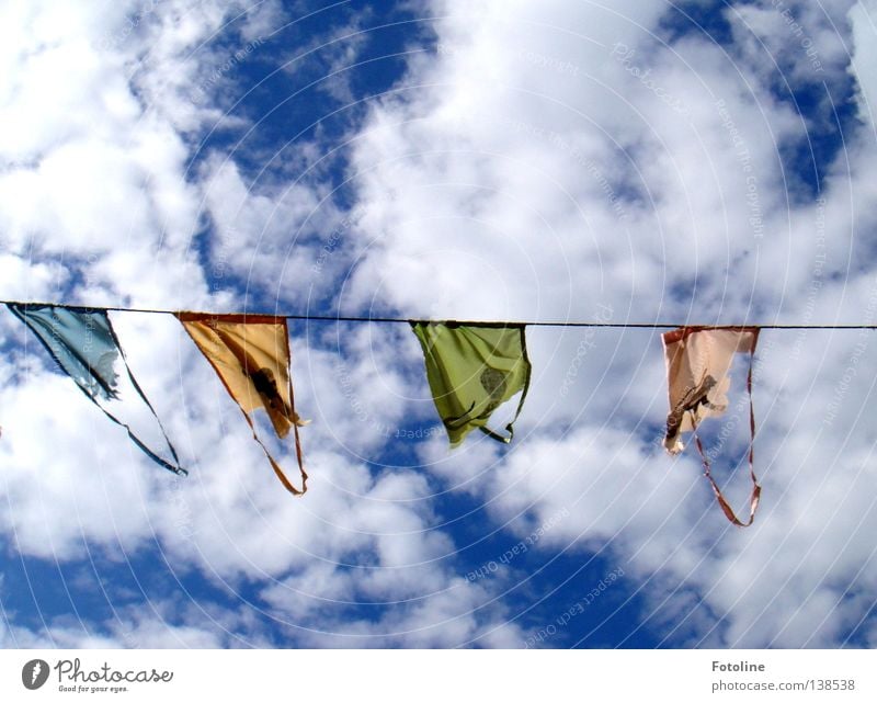 Wimpel an einer Leine vor blauem Himmel mit vielen dicken Wolken Farbfoto mehrfarbig Außenaufnahme Menschenleer Textfreiraum oben Textfreiraum unten Tag