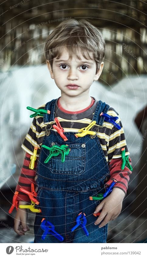 boy Kind blond Streifen T-Shirt Kleinkind child sad sadness play playful hair blue Jeanshose clamp toy childhood face eyes Caucasian looking serious standing