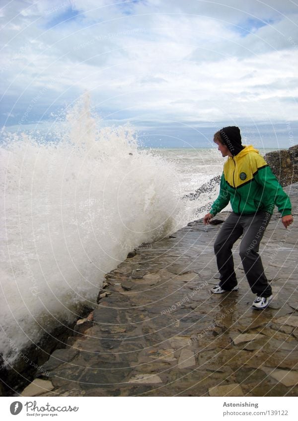 Angst Meer Wellen Mensch Mann Erwachsene Natur Wasser Himmel Wolken Wetter Regen Felsen Jacke Stein Bewegung stehen gelb grün Respekt Brandung Wassermassen