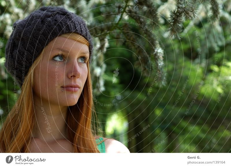 Aufsehen grün Wald Baum Mütze Frau Junge Frau schön langhaarig Porträt Gesichtsausdruck Blick rothaarig Kopfbedeckung Natur Kiefer Ast hintergrundunschärfe