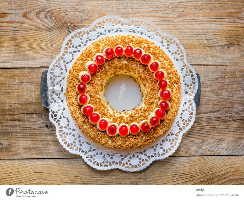 Frankfurter Kranz mit Kirschen auf rustikal Holz Kuchen Dessert süß Buttercremetorte ringförmig kranzförmig Schaumgebäck Sahne Torte Tortenspitze Backwaren