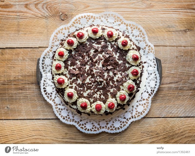 Schwarzwälder Kirschtorte auf rustikal Holz Kuchen Dessert süß Torte Sahnetorte Kirsche Schaumgebäck Tortenspitze Backwaren Biskuit Holztisch Vogelperspektive