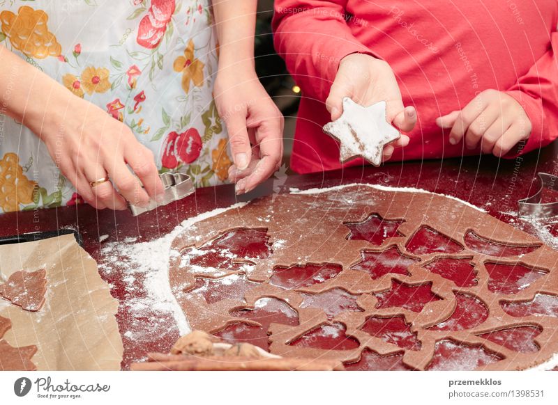 Die Weihnachtssymbole im Teig für die Plätzchen herausschneiden Tisch Küche Mensch Mädchen Frau Erwachsene Hand 2 8-13 Jahre Kind Kindheit 30-45 Jahre machen