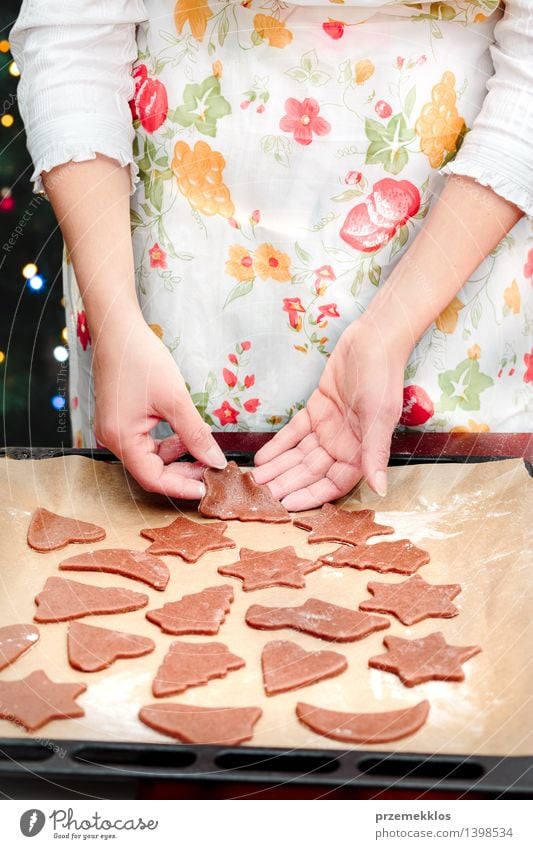 Die Weihnachtssymbole im Teig für die Plätzchen herausschneiden Tisch Küche Mensch Frau Erwachsene Hand 1 30-45 Jahre machen geschnitten Mehl Lebkuchen