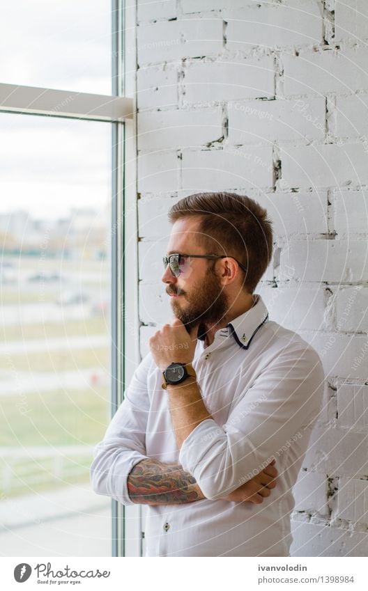 Bärtiger Mann in der Sonnenbrille, die das Fenster betrachtet Lifestyle elegant Stil Haare & Frisuren Gesicht Mensch maskulin Erwachsene Mode Hemd