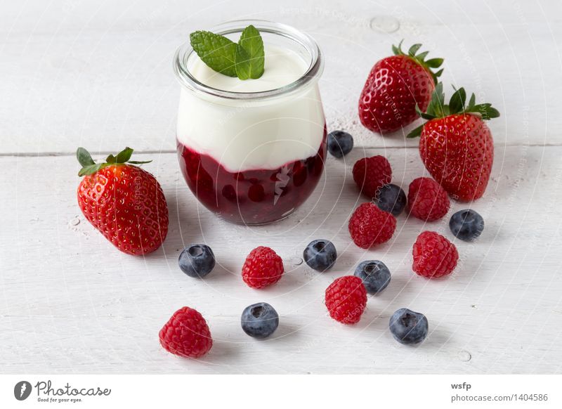 Rote Grütze mit Minze Joghurt Frucht Dessert Holz weiß rote Grütze Himbeeren Blaubeeren weisser Holzhintergrund Erdbeeren Glas Gesund Süsspeise Essen Holztisch