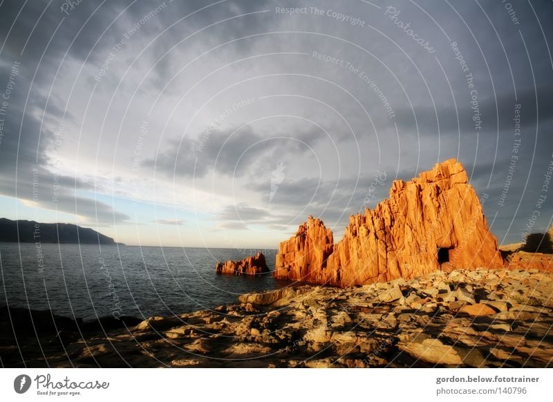 roter Fels Sonnenuntergang Abenddämmerung Sardinien Italien Brandung Meer Wasser Felsen Stein Himmel