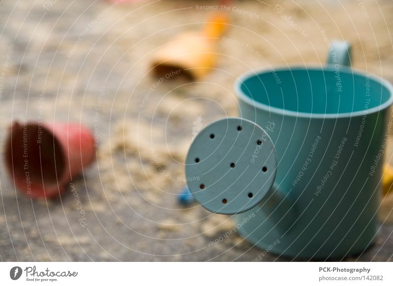 sandplatzspiele Sandkasten Gießkanne Schaufel Eimer Kübel Makroaufnahme blau gelb rot Nahaufnahme