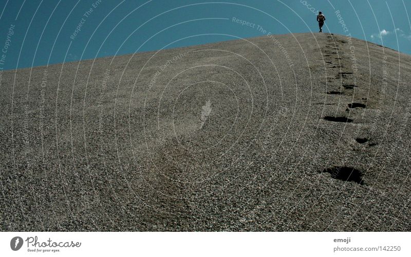 alleine in der Welt Kies Kiesberg Hügel Kiesgrube Baggersee klein Fußspur schreiten gehen zyan Mann Einsamkeit Himmel Gegenlicht Mensch stehen Kraft