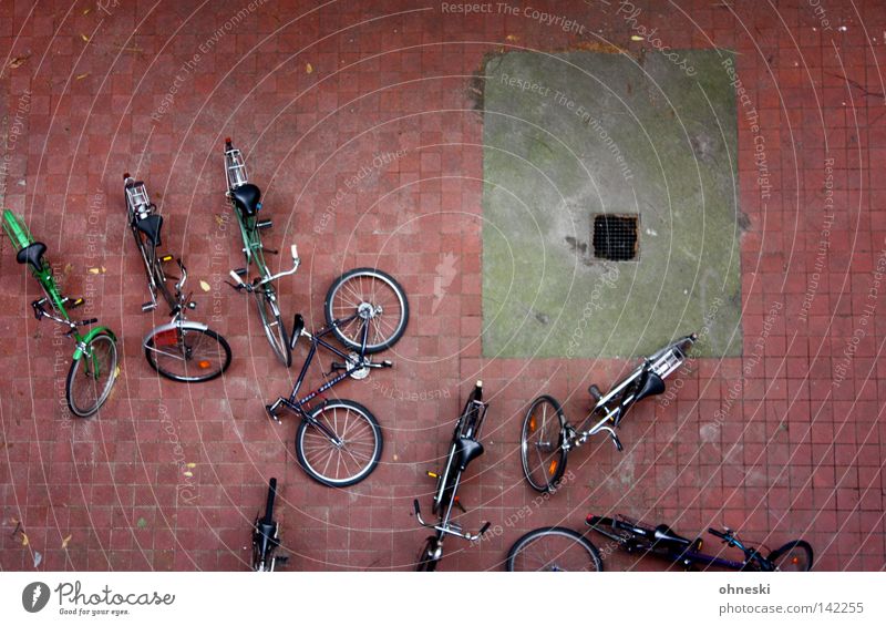 Die Räder im Hof Fahrrad Vogelperspektive umgeknickt Hinterhof Pause Abfluss Pflastersteine Stein umgefallen parken Parkplatz Reifen ruhig Einsamkeit