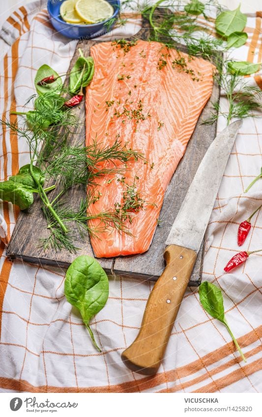 Lachs Fischfilets auf Schneidebrett mit Messer Lebensmittel Gemüse Salat Salatbeilage Kräuter & Gewürze Ernährung Mittagessen Abendessen Festessen Bioprodukte