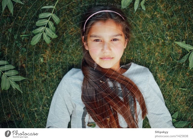 Kleines Mädchen, das auf dem Gras liegt Sommer Sonne Mensch Kind Schwester Körper Haare & Frisuren Gesicht Auge Lippen 1 8-13 Jahre Kindheit Garten Park brünett